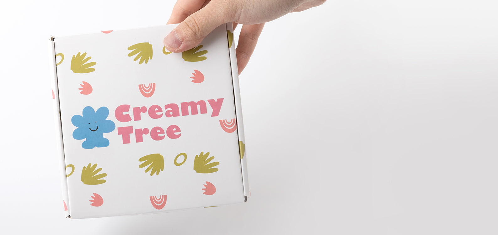 A hand holding Creamy Tree’s simple and cute packaging