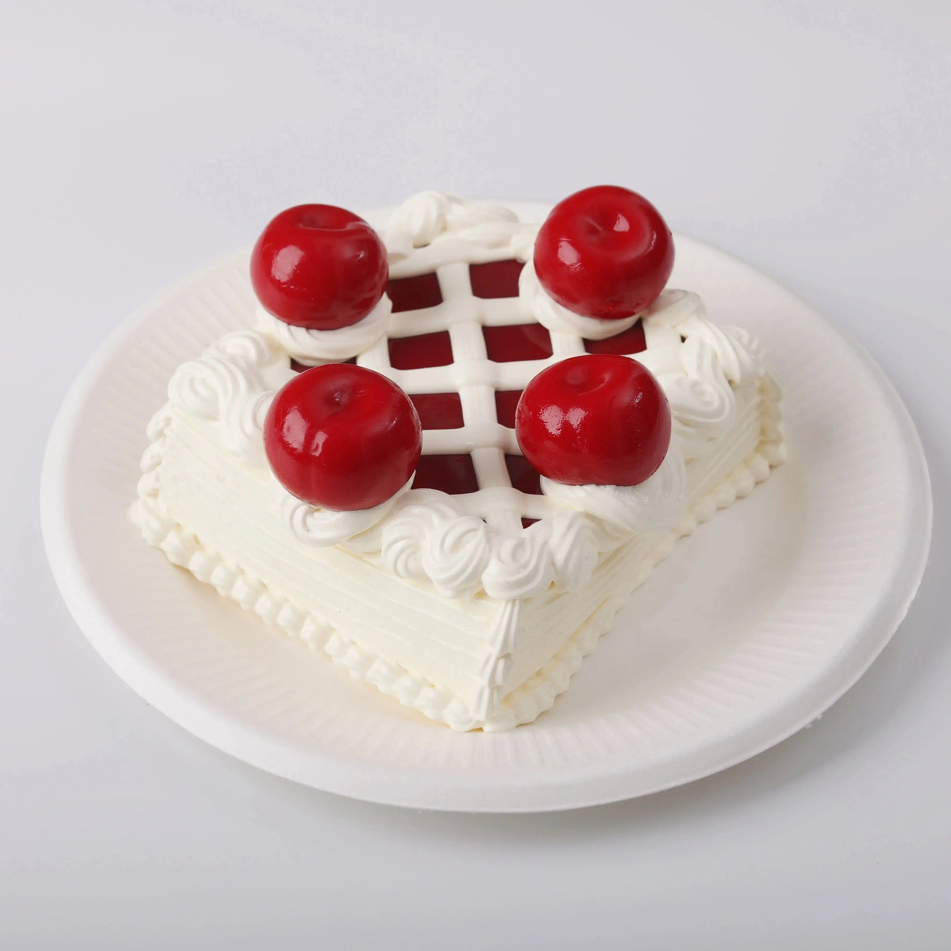 Sheryl Cherry Cake Squishy Toy on a white plate