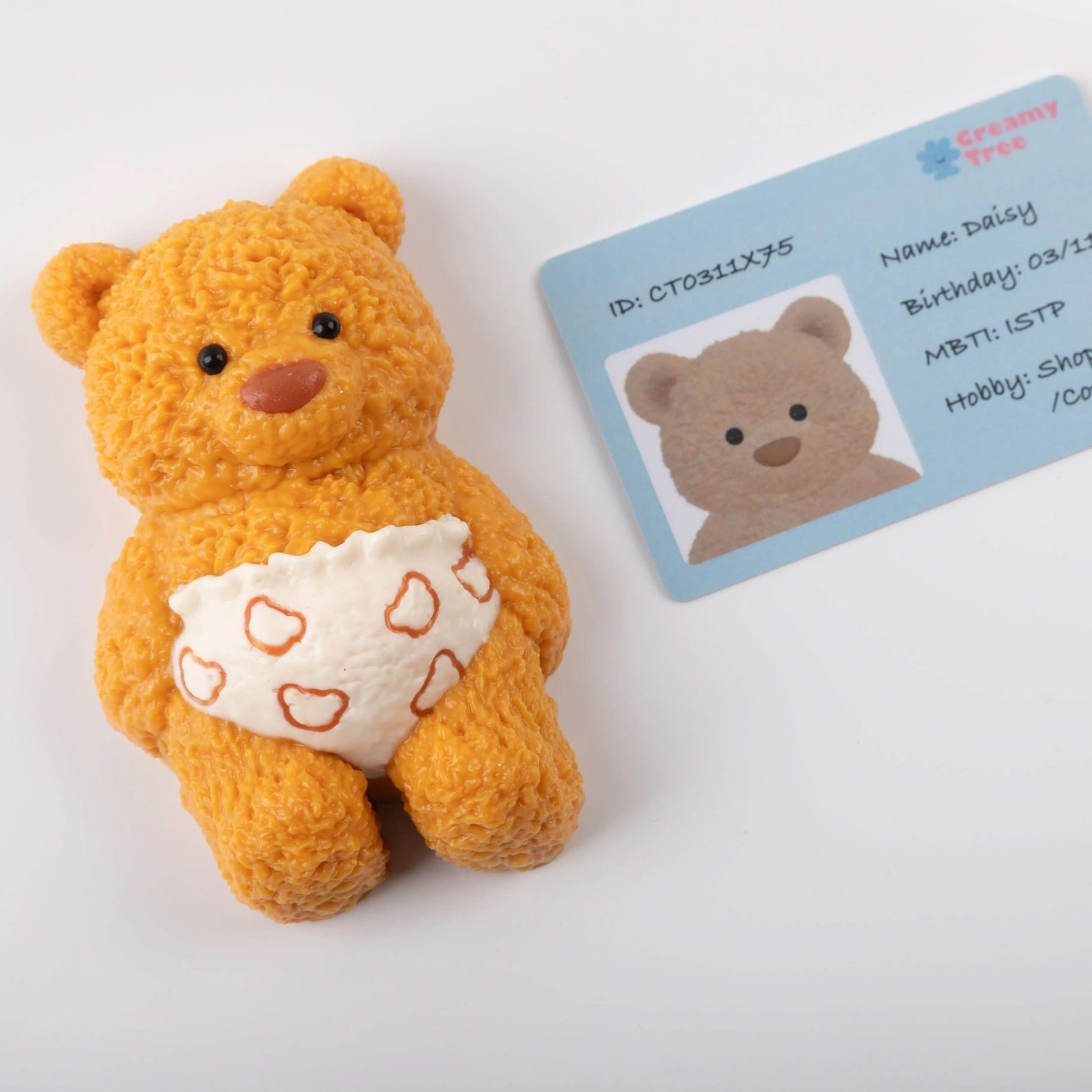 Close-up of stress toy bear with character ID card on white background