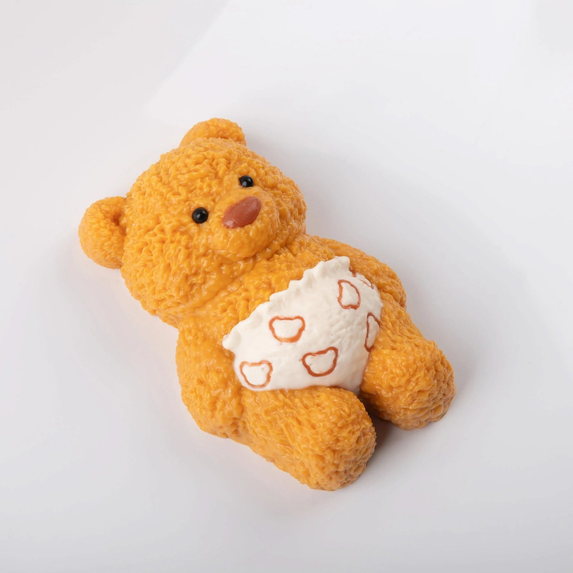 Side view of Creamy Tree teddy bear stress toy with white heart-patterned diaper
