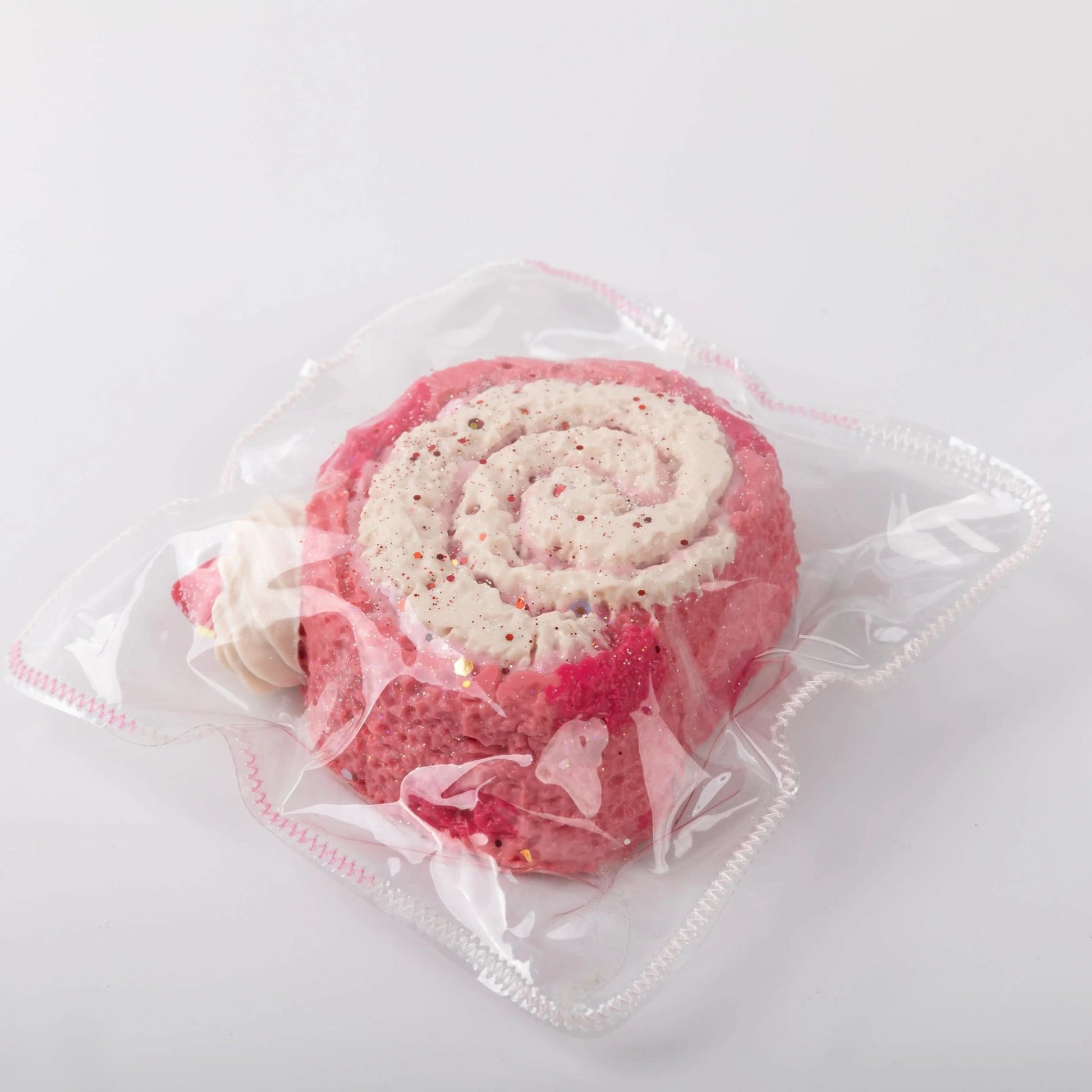 Side view of Pink and White Creamy Tree Puff Swiss Roll Squishy toy with strawberry