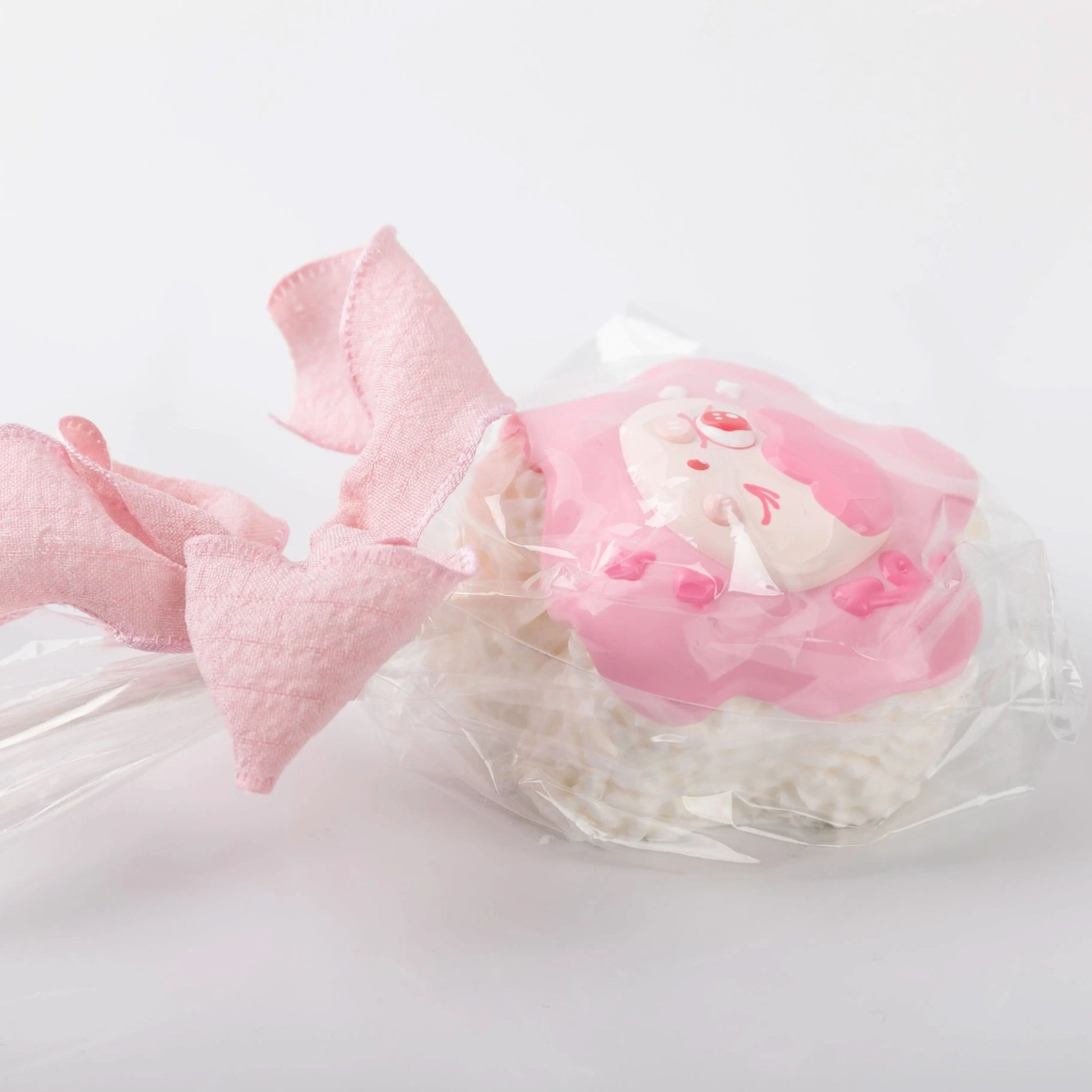 Detailed view of pink bow and textured layers on lollipop squishy toy
