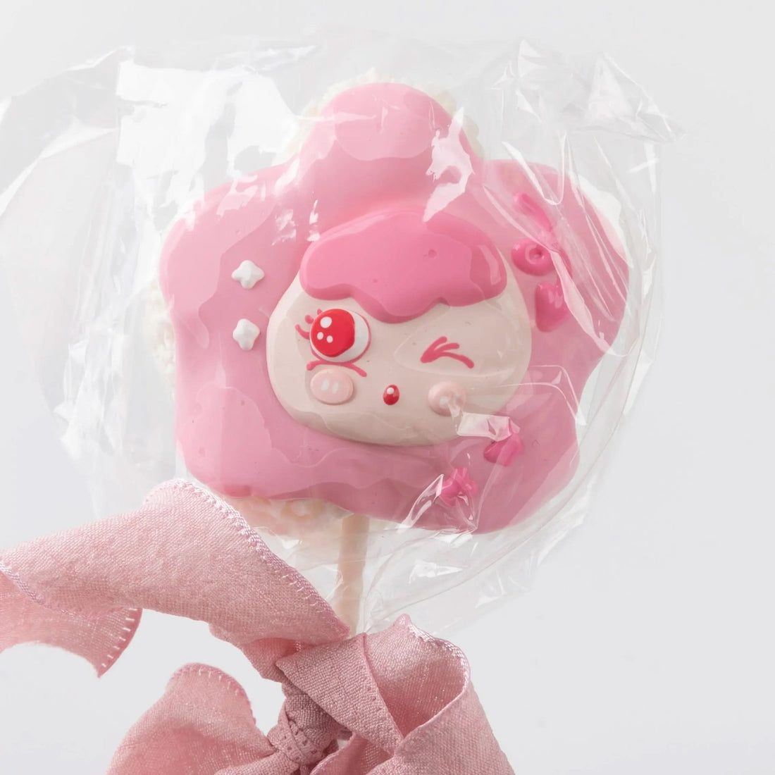 Front view of Creamy Tree Pink Lollipop Squishy toy with a cute girl face and a pink bow