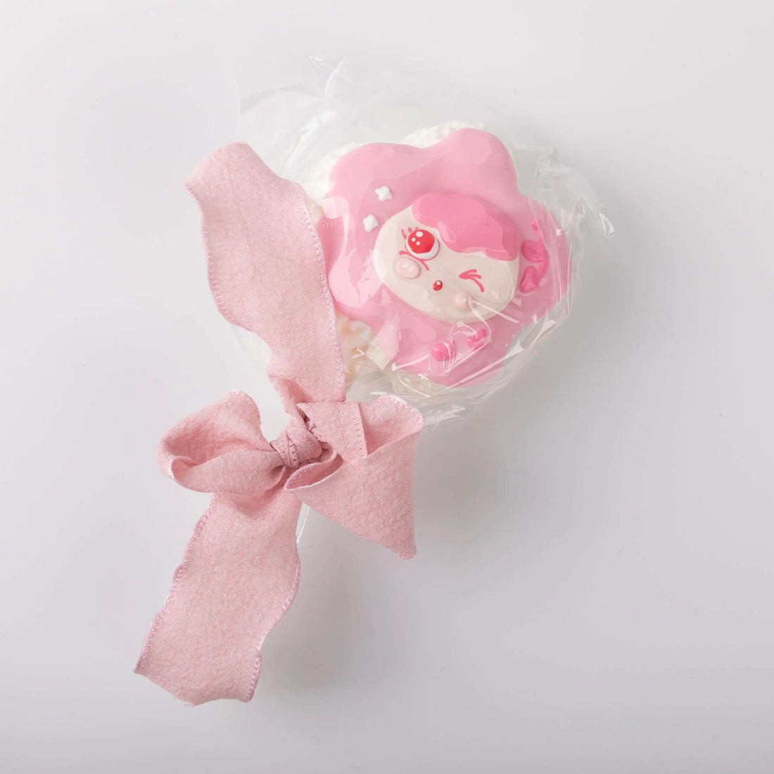 Front view of Creamy Tree Pink Lollipop Squishy toy with a cute girl face and a pink bow